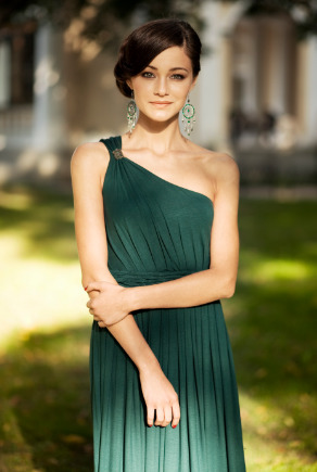 Frau mit grünem Abendkleid und Ethno-Ohrringen