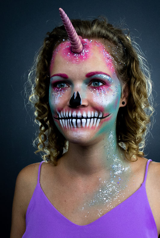 Frau mit gruseligem Einhorn-Make-Up für Halloween