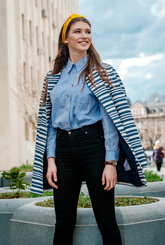 Street Style: Brünette Frau in hellblauer Bluse und schwarzer High-Waist-Jeans