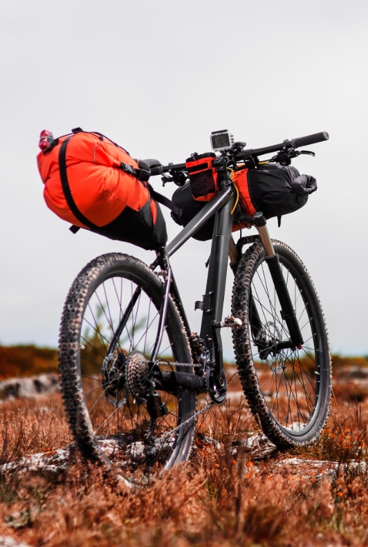Schwarzes Mountainbike mit Fahrradtaschen in orange