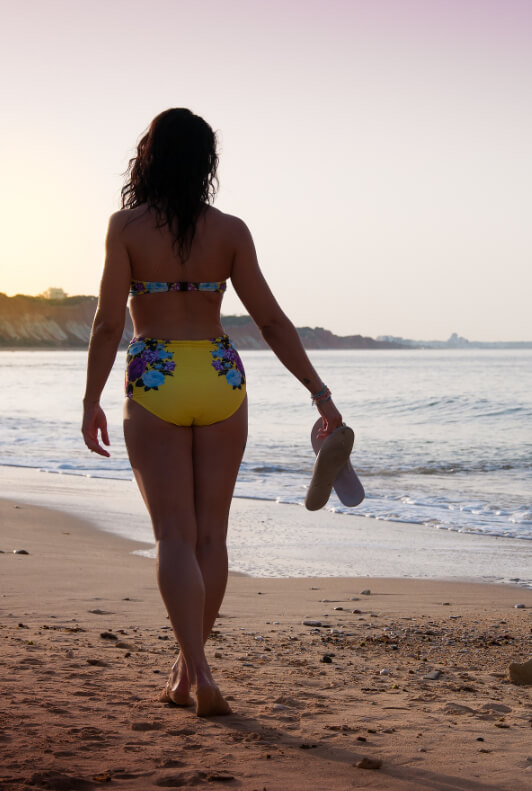 Frau am Strand mit gelbem High Waist Biniki