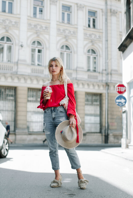 Street Style: Blonde Frau mit roter Carmenbluse und Ripped-Jeans