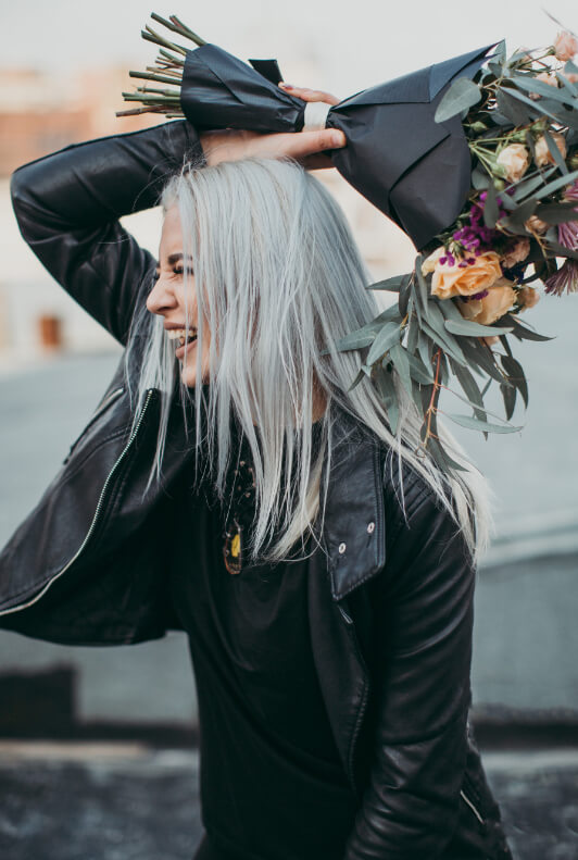 Frau mit Blumen in schwarzer Lederjacke