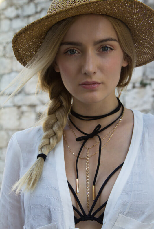 Blonde junge Frau mit Choker-Halsband und Strohhut