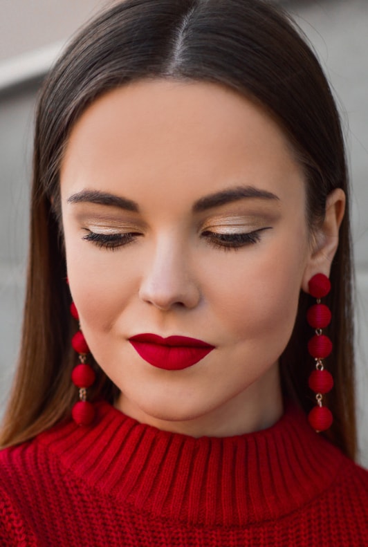 Frau mit festlichem Make-up mit rotem Lippenstift und goldenem Lidschatten