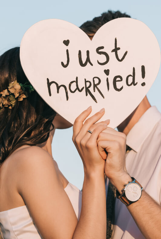 Hochzeitspaar hinter einem Just-Married-Schild