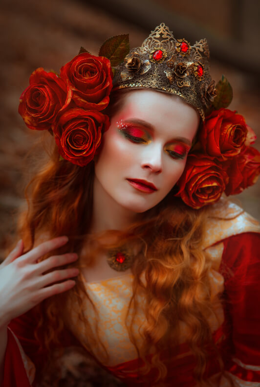 Frau in Königin Kostüm mit Blumen an der Krone