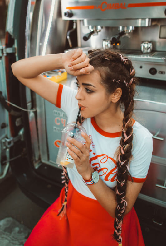 Junge Frau mit Boxer-Braids und Logo-Shirt von Coca Cola