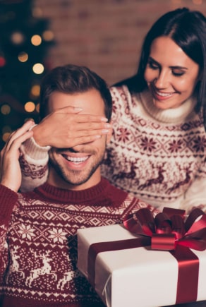 Mann wird von Frau zu Weihnachten beschenkt