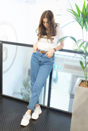 Mode-Bloggerin HeyJulie mit blauer Mom-Jeans, weißem Shirt und weißen Sneakern
