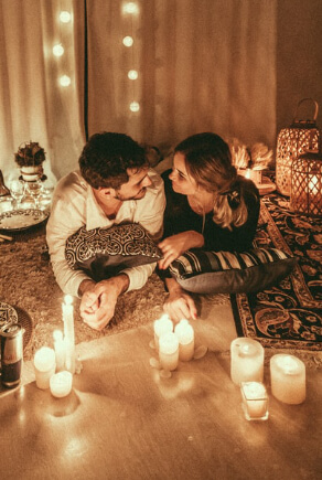 Paar sitzt bei Kerzenlicht zusammen auf der Couch