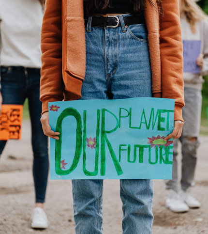 Person mit Plakat "Our Planet Future"